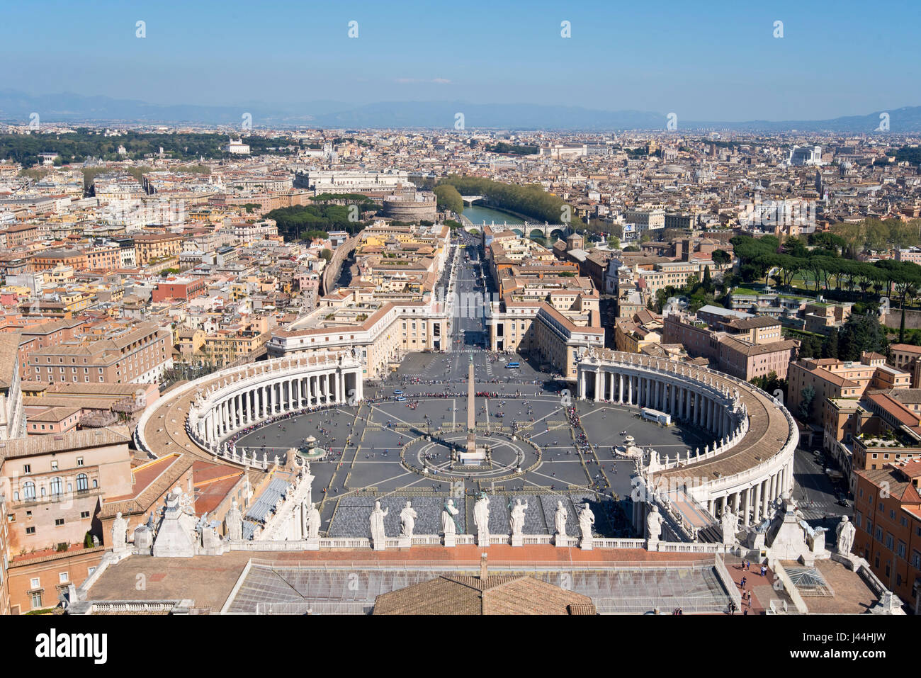 Ein Blick auf dem Petersplatz Piazza San Pietro vor Str. Peters Basilica und Stadtbild über Rom an einem sonnigen Tag mit blauem Himmel. Stockfoto