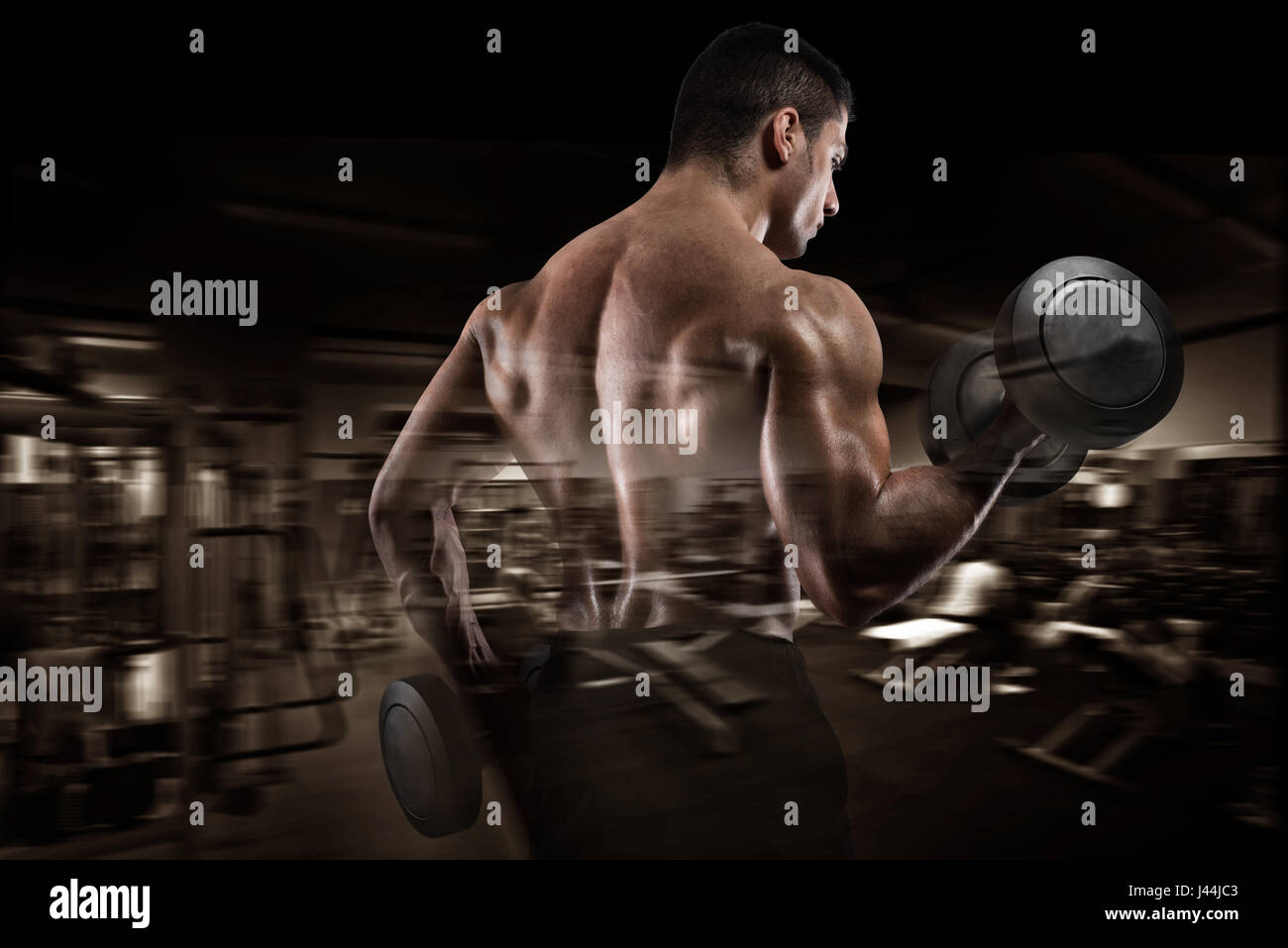 Sportlicher Mann Training Bizeps auf Fitness-Studio-Hintergrund Stockfoto