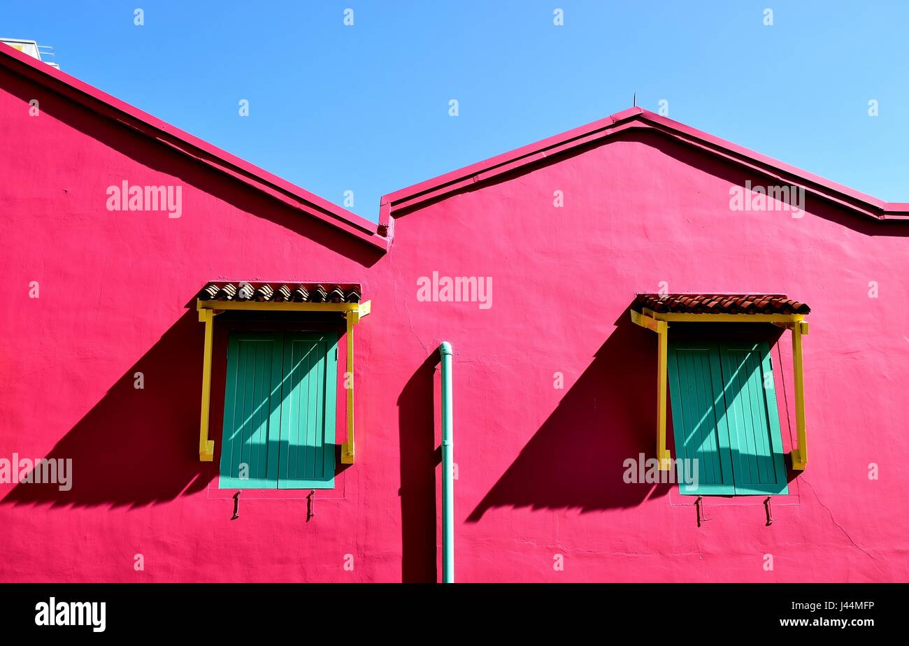 Fett Rosa von außen ein traditionelles Singapur shop Haus mit Fensterläden aus Holz unter einem blauen Himmel Stockfoto