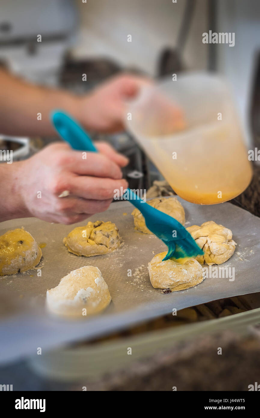 Ein Koch putzt ein Ei waschen, um Teig Küche Essen Kochen Backen Restaurant Lebensmittelzubereitung Lebensmittelservice Industrie Arbeiter arbeiten Stockfoto