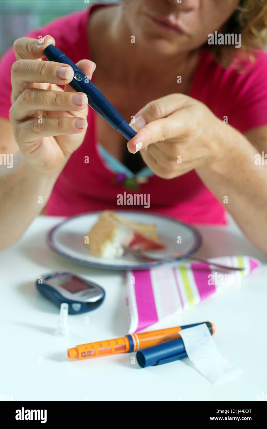 Nahaufnahme einer Frau mit Lancelot auf Finger Probe des Blutzuckers nehmen. Stockfoto