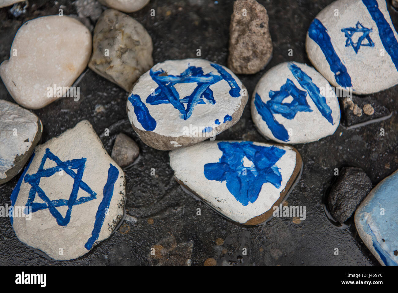 Handgemalte Steinen mit dem Davidstern gemalt durch Besucher am Fuße des Warschauer Ghetto Helden Denkmal links. Stockfoto