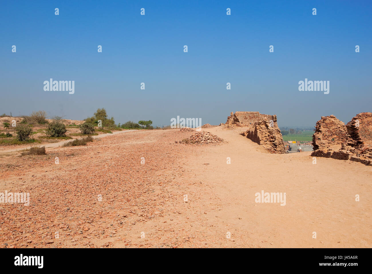 Restaurierungsarbeiten an der Spitze der Bhatner Festung Rajasthan Indien mit Akazien und Ziegel Bauschutt und einen Blick auf ferne Landschaft unter blauem Himmel in s Stockfoto