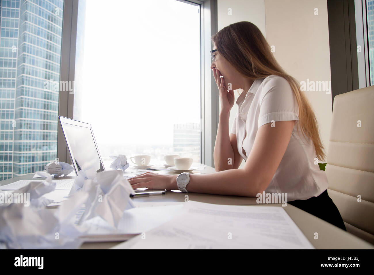 Müde Geschäftsfrau Gähnen am Schreibtisch mit laptop Stockfoto