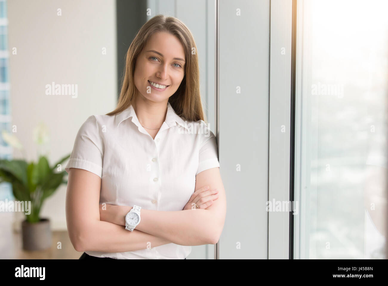 Lächelnde Geschäftsfrau optimistisch im Büro Stockfoto