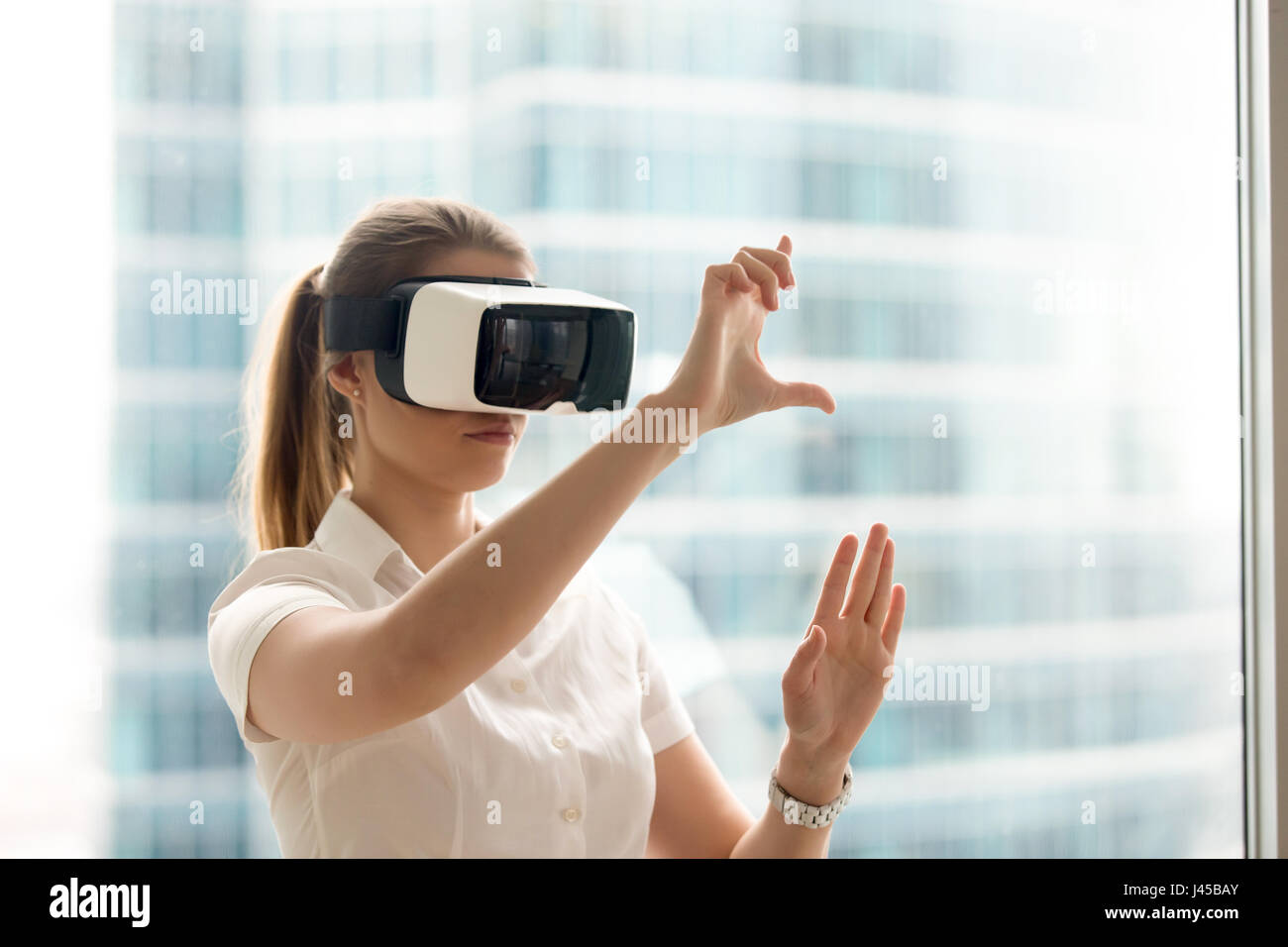 Mädchen mit streichen und stretch-Geste in VR-Brillen Stockfoto