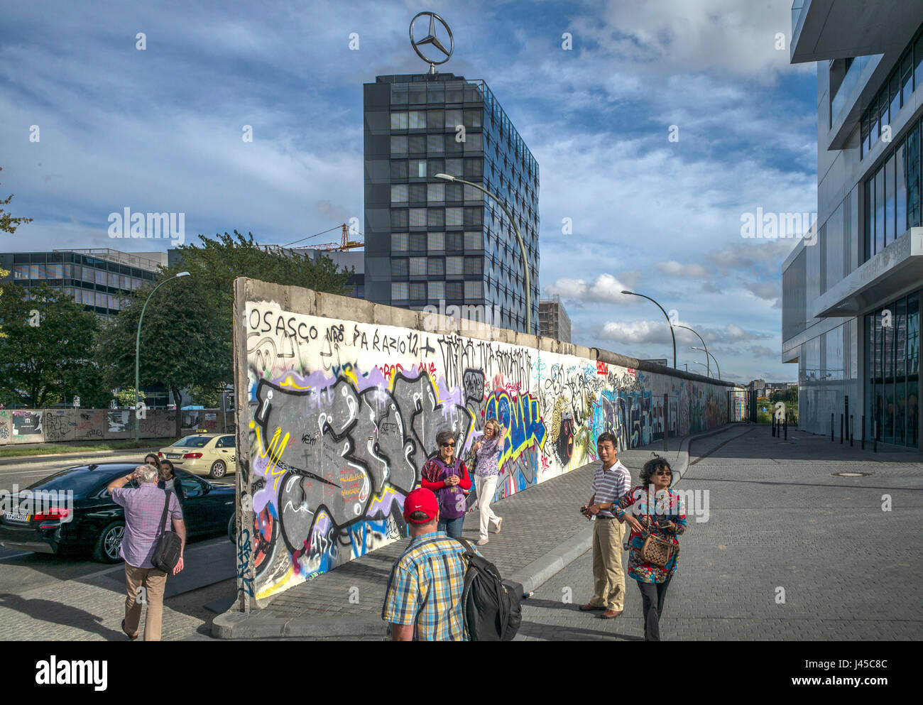 Touristen fotografieren eines Teils der East Side Gallery auf Website der paar letzten verbleibenden Teile der Berliner Mauer geschmückt, Mühlenstraße, Berlin Stockfoto