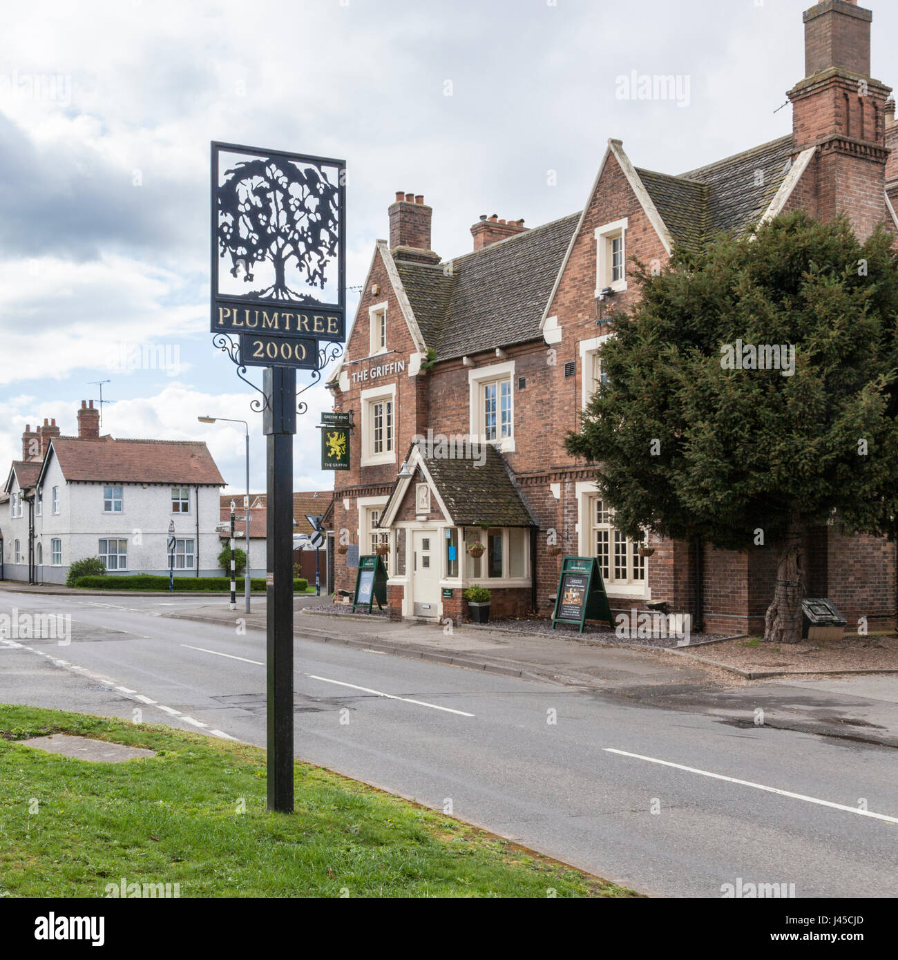 Plumtree Dorf Schild mit dem Griffin Pub auf der anderen Straßenseite. Plumtree, Nottinghamshire, England, Großbritannien Stockfoto