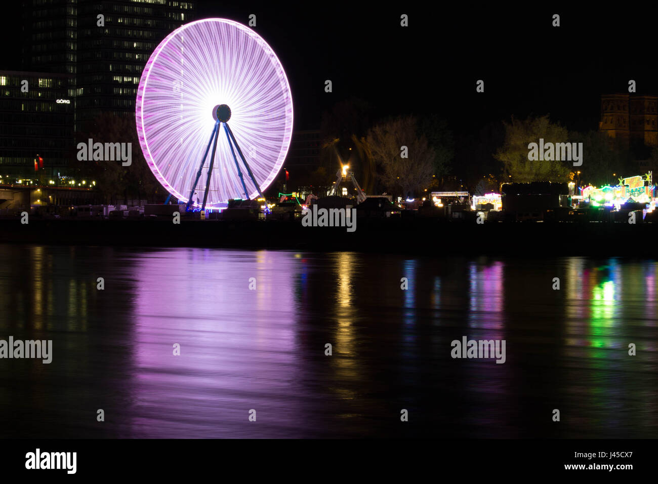 Riesenrad am Abend mit bunten Reflexionen im Fluss Stockfoto