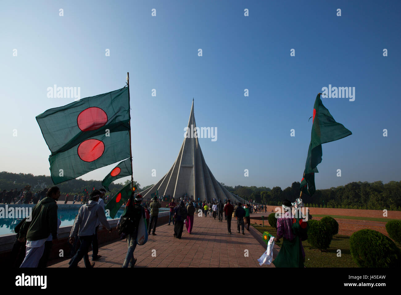 Straßenhändler verkaufen Bangladeshi Nationalflaggen am National Memorial Tower oder Jatiya Smriti Shoudha bei Savar am Tag des Sieges. Dhaka, Bangladesch Stockfoto