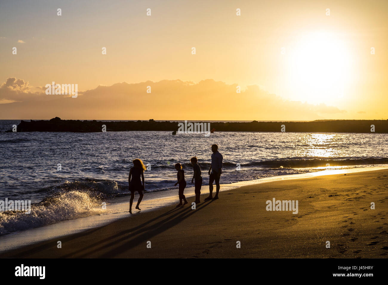 Silhouetten von einer Familie am Strand bei Sonnenuntergang (Teneriffa, Spanien) Stockfoto