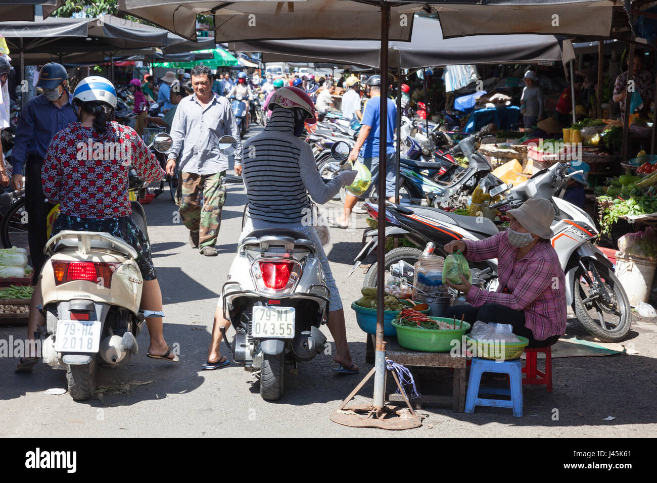 NHA TRANG, VIETNAM - Dezember 12: Frau Gurken auf dem nassen Markt am 12. Dezember 2015 in Nha Trang, Vietnam verkauft. Stockfoto