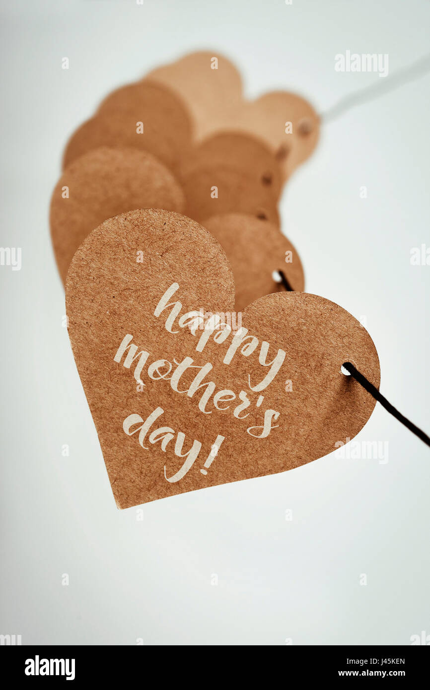 Nahaufnahme von einige braune Pappen Herzen aufgereiht auf eine Zeichenfolge und der Text happy Muttertag, geschrieben in der ersten, eine wollweiße Hintergrund Stockfoto