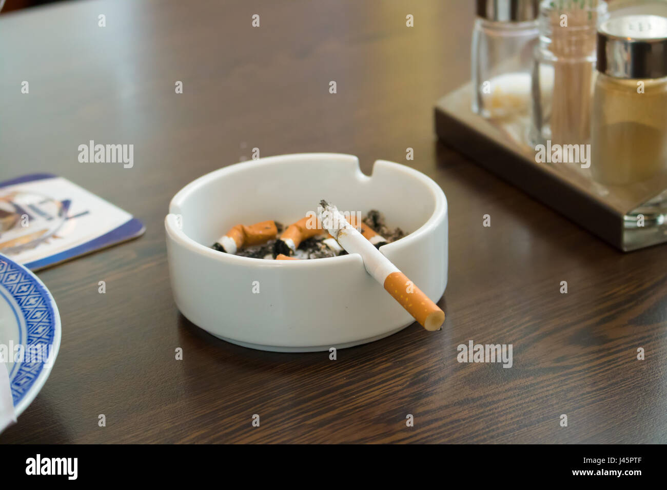 Aschenbecher und Zigaretten, auf einem Tisch, Asche, Tablett, Glas