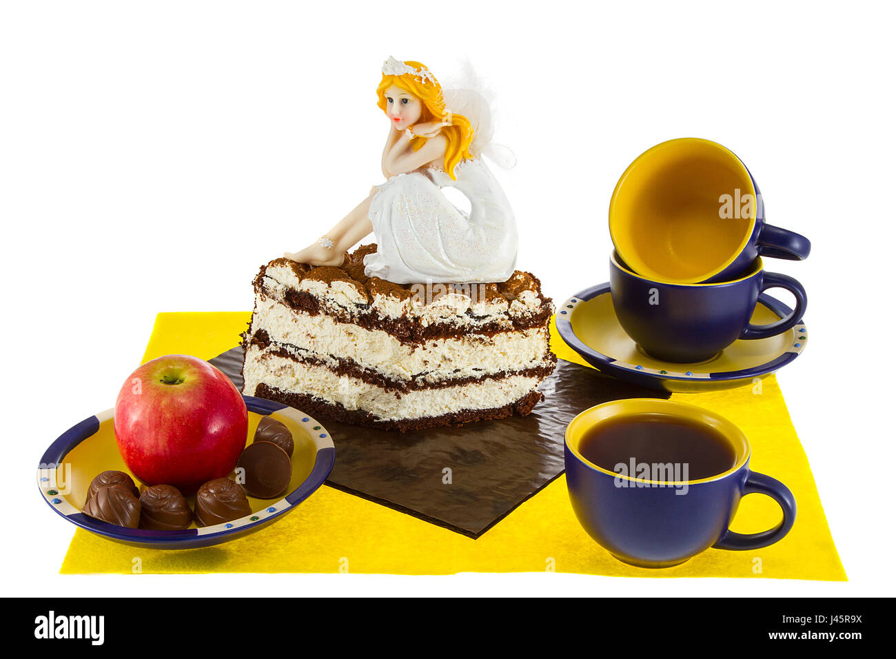 ein Stillleben Süßigkeiten und Tee mit eine wunderschöne Puppe auf dem Kuchen Stockfoto