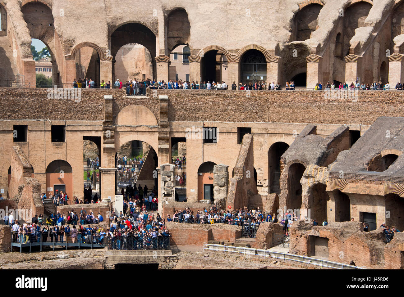 Eine komprimierte Sicht Innenansicht des Amphitheaters im Inneren des Kolosseums mit Touristen Besucher an einem sonnigen Tag vom Boden genommen. Stockfoto