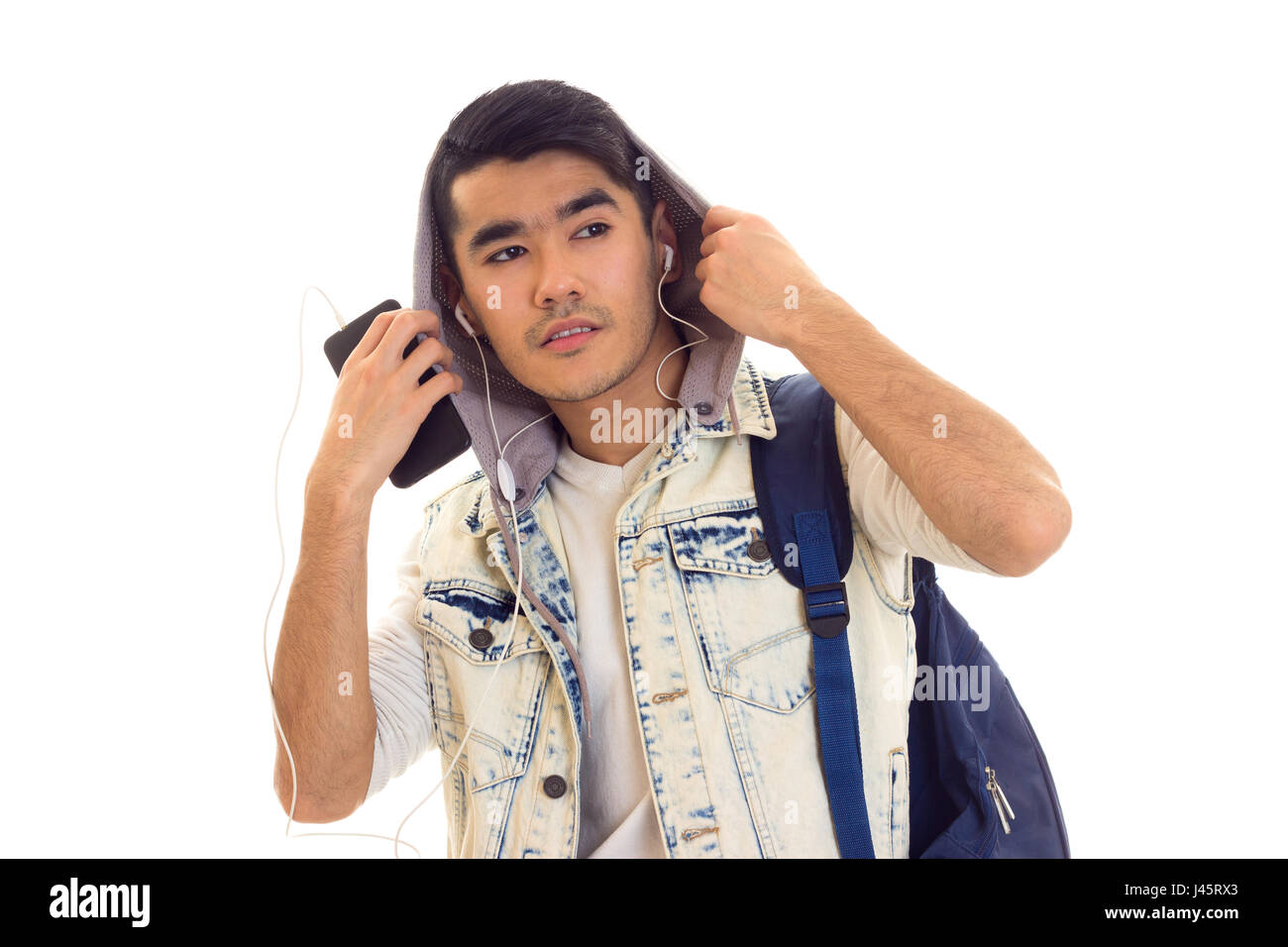 Junger Mann mit Rucksack, Smartphone und Kopfhörer Stockfoto