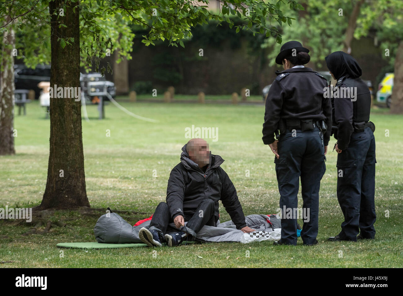 Polizisten-Frage dann bewegen sich auf eine grobe Schläfer in Londons Geraldine Mary Harmsworth Park. VEREINIGTES KÖNIGREICH. Stockfoto