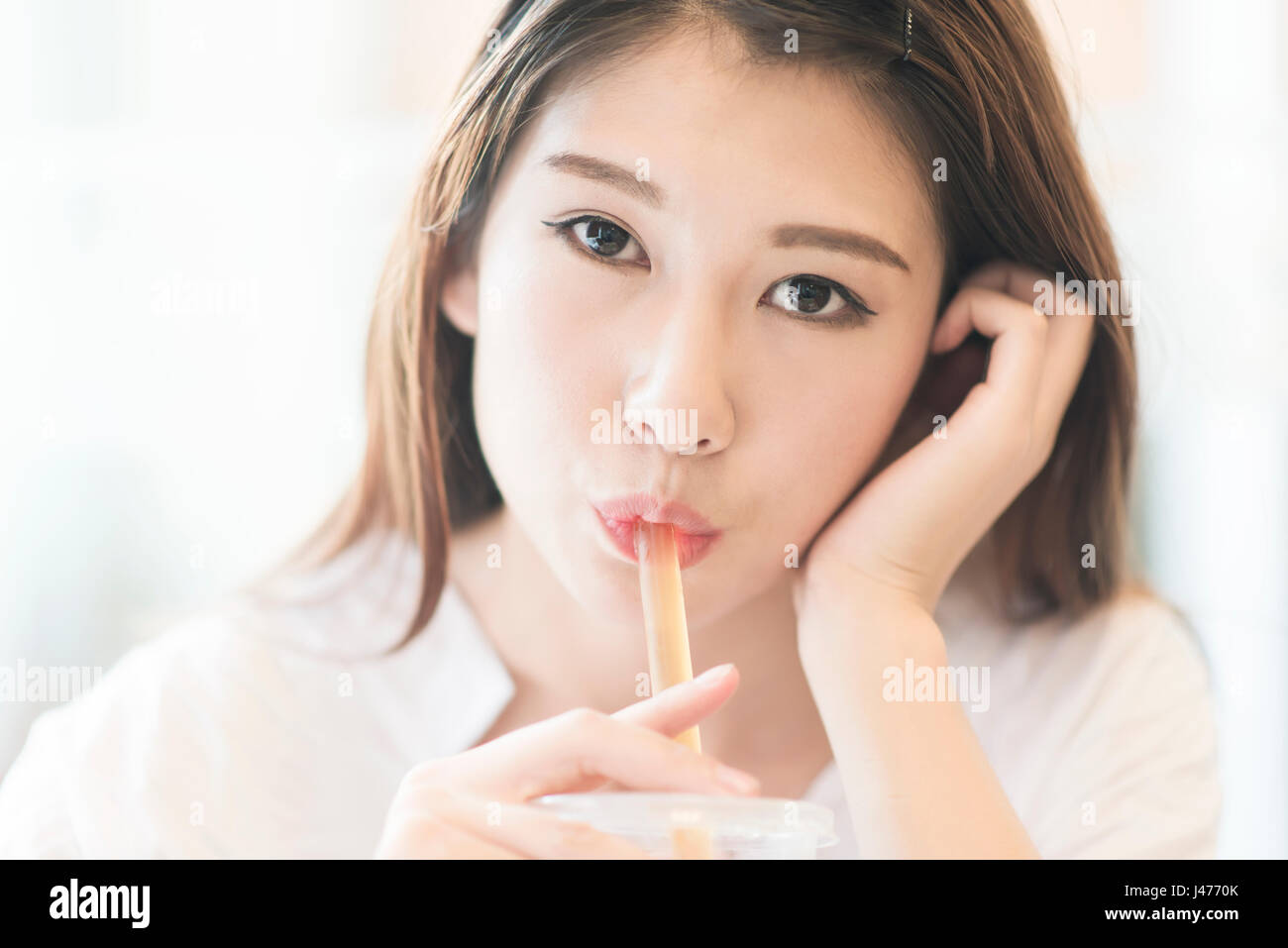 schöne asiatische Mädchen glücklich trinken orange Saft Stockfoto