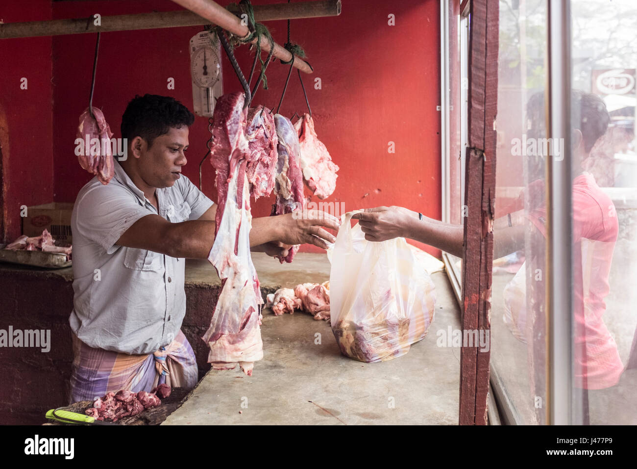 Ein muslimischer Metzger dient ein Kunde in einem Geschäft in Negombo, Sri Lanka. Stockfoto