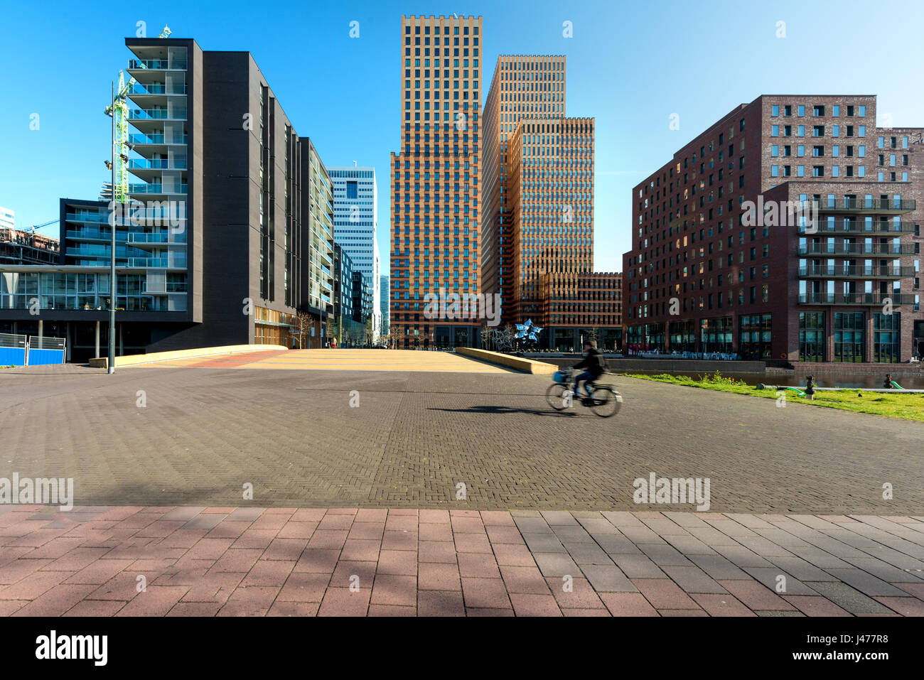 Wolkenkratzer von Amsterdam, Niederlande. Bürogebäude in Amsterdam Zuid, Amsterdam, Niederlande. Menschen, die Radfahren in Amsterdam, Niederlande Stockfoto
