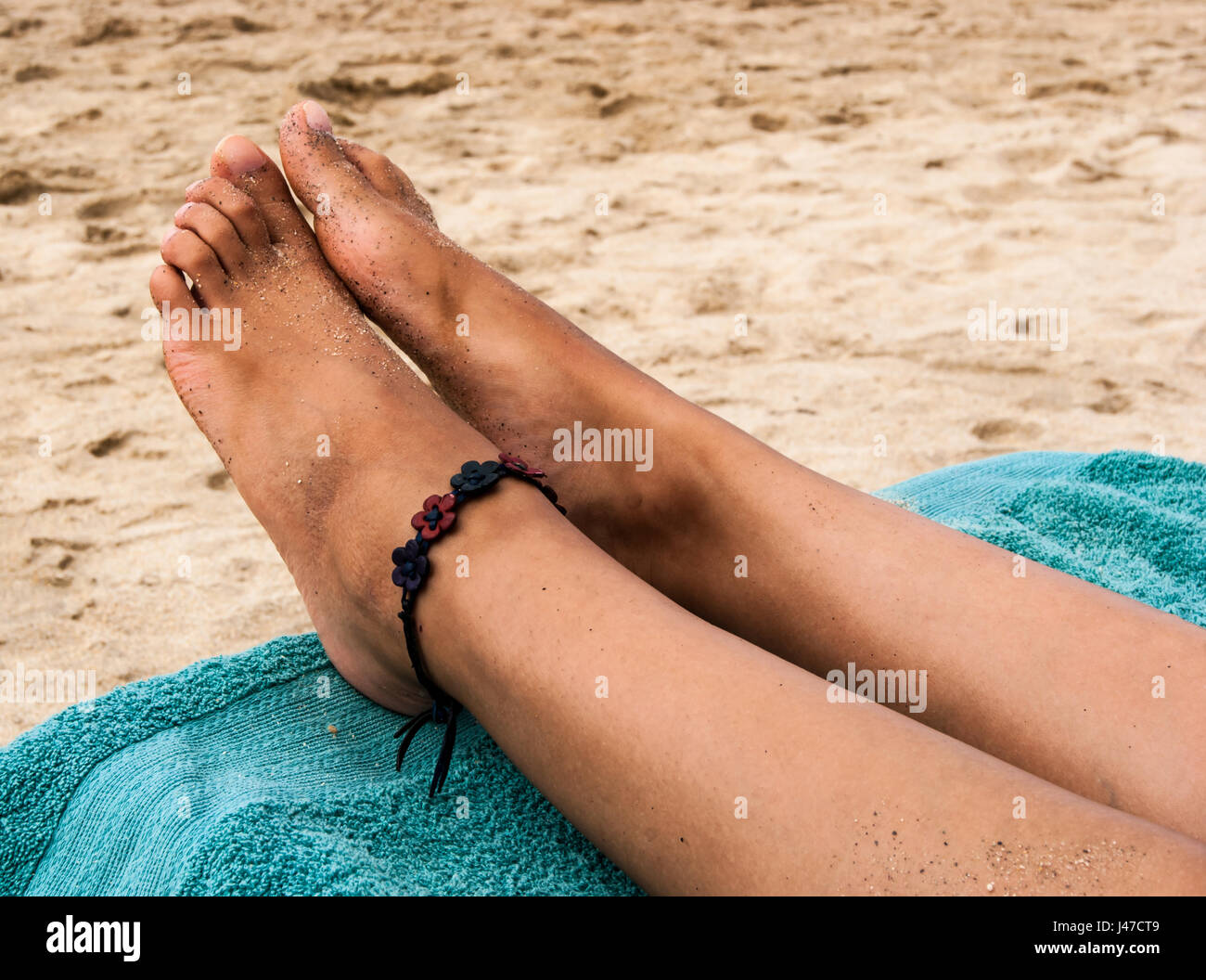 schöne Füße einer jungen Dame, die am Strand entspannen Stockfoto
