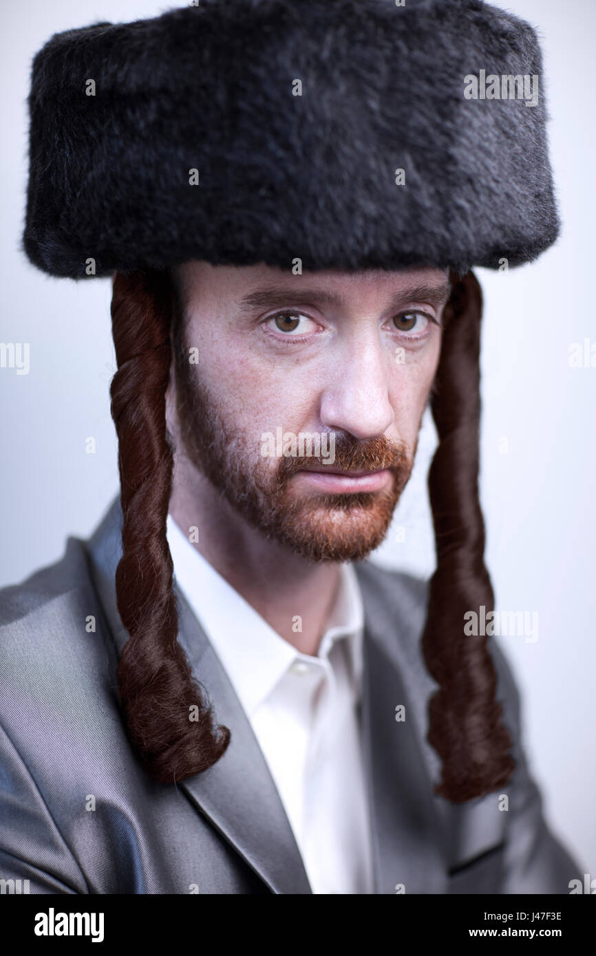 Hübscher orthodoxen jüdischen Mann Chassidim Rabbi mit roten Bart im großen Pelz Hut und Seite sperren in einem silbernen Haifischhaut-Anzug Stockfoto