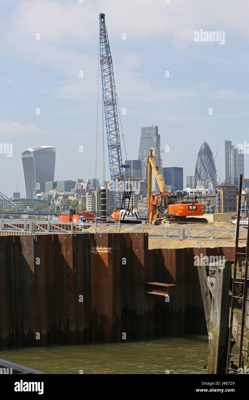 Thames Tideway Projekt, London. Ein Bagger und Kran stehen auf eine temporäre Kofferdamm in Kammern Wharf, Bermondsey. Der Londoner Skyline hinaus. Stockfoto