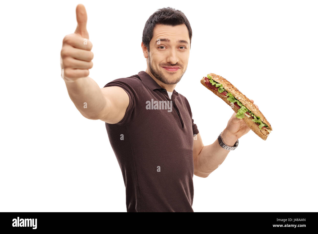 Junger Mann mit einem Sandwich machen einen Daumen Schild isoliert auf weißem Hintergrund Stockfoto