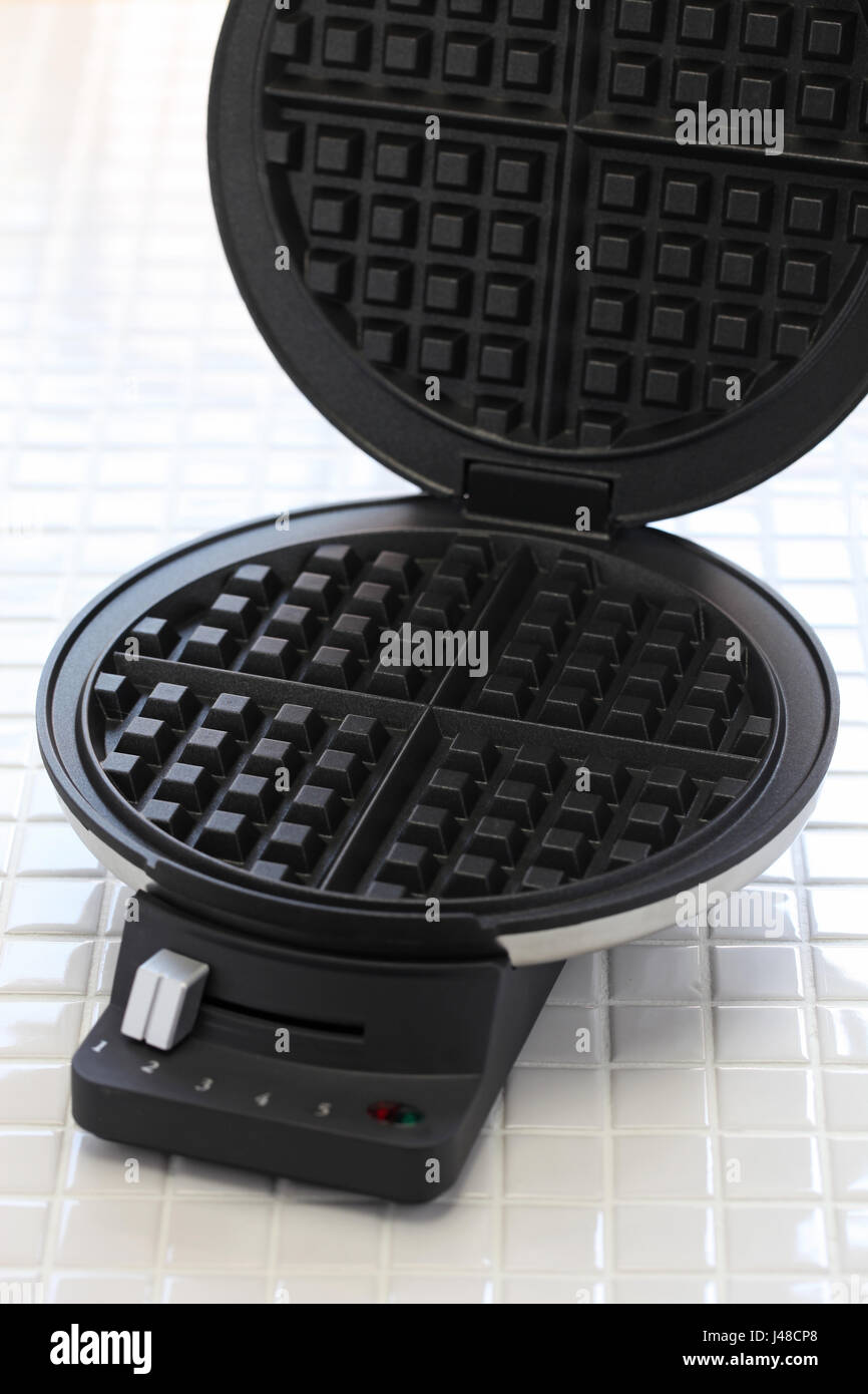 hausgemachte Waffeln vorbereiten von Waffle Maker Maschine. Stockfoto