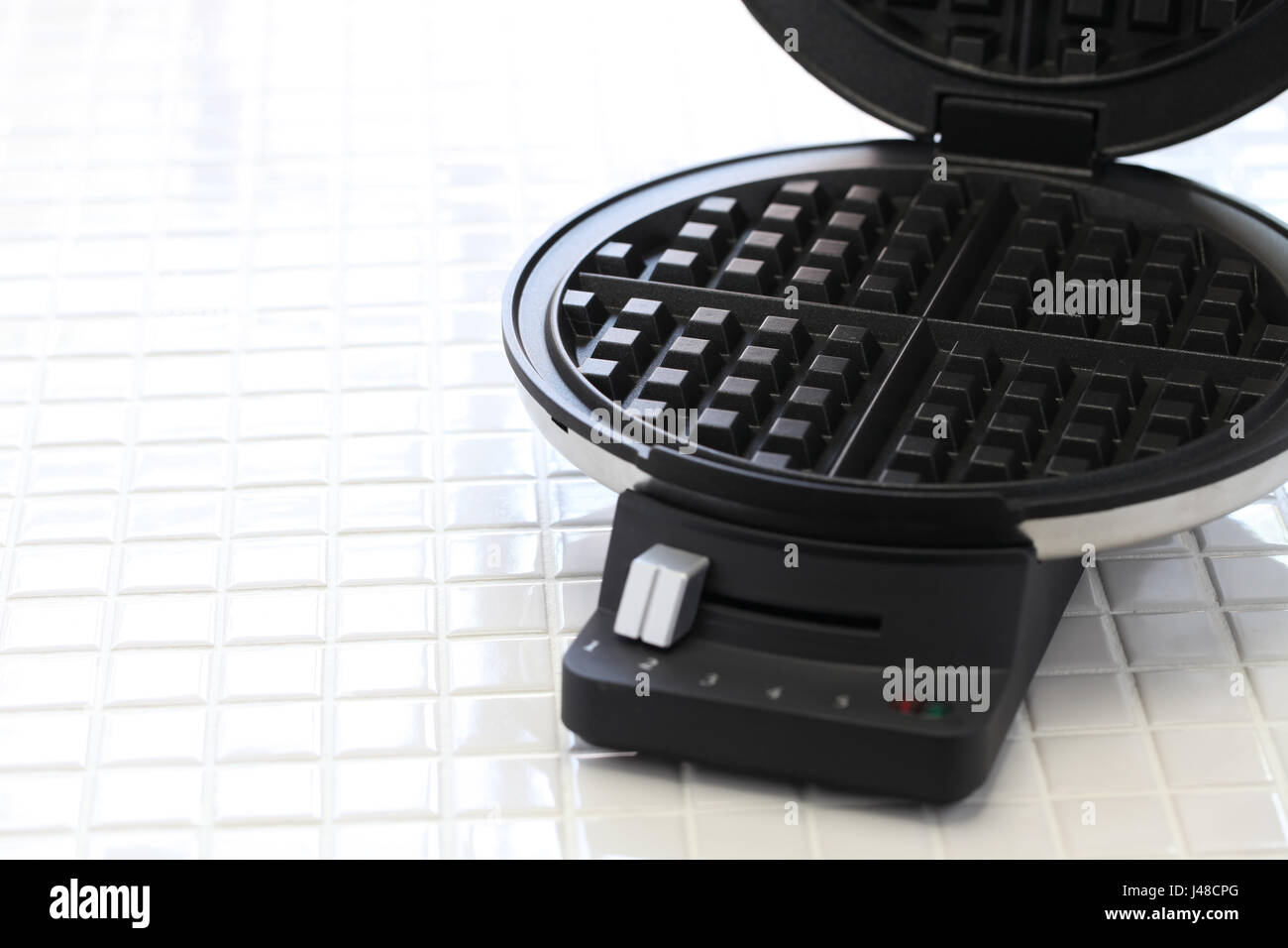 hausgemachte Waffeln vorbereiten von Waffle Maker Maschine. Stockfoto