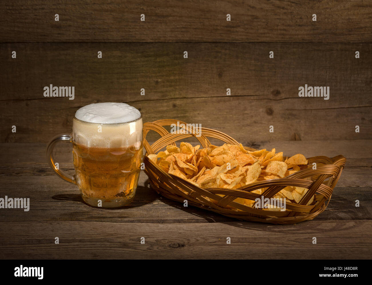 Glas Bier vom Fass und Chips auf hölzernen Hintergrund Stockfoto