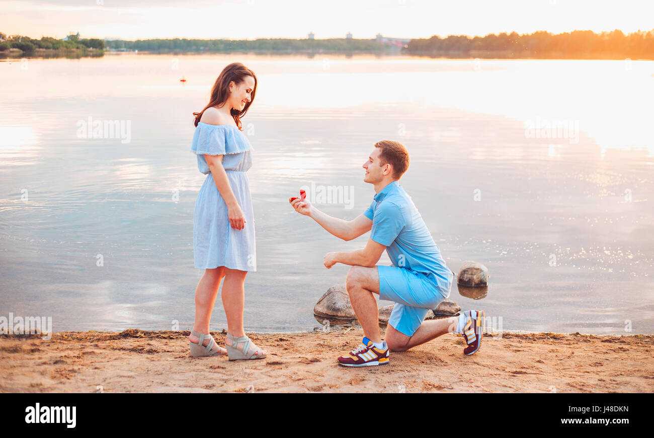 Heiratsantrag bei Sonnenuntergang. junger Mann macht einen Vorschlag der Verlobung mit seiner Freundin am Strand Stockfoto
