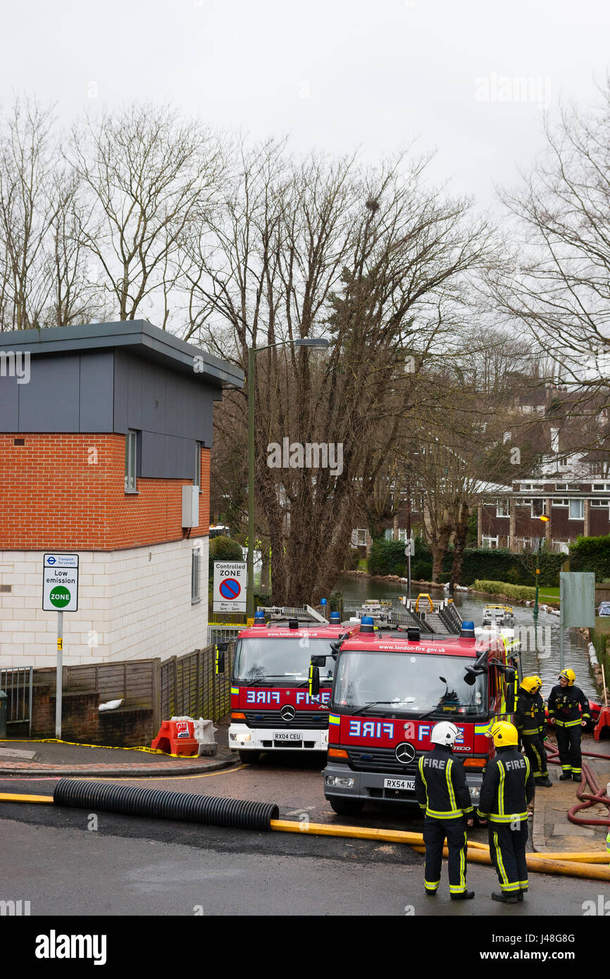 Purley, London, UK. Feuerwehrleute arbeiten, um Pumpe Hochwasser vom Wohnstraße. Stockfoto