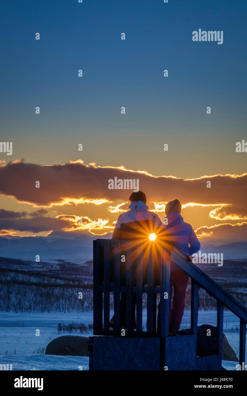 Paar genießt einen Winter Sonnenuntergang, Lappland, Schweden Stockfoto