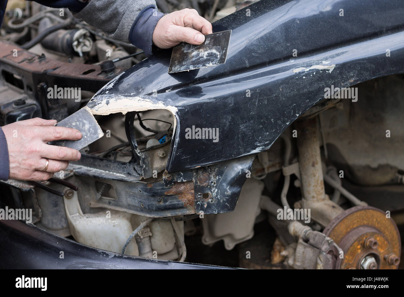 Arbeiter Deckel Auto Dellen mit Füllmaterial Kitt von Spachtel aus Metall.  Auto Reparatur Service Stockfotografie - Alamy