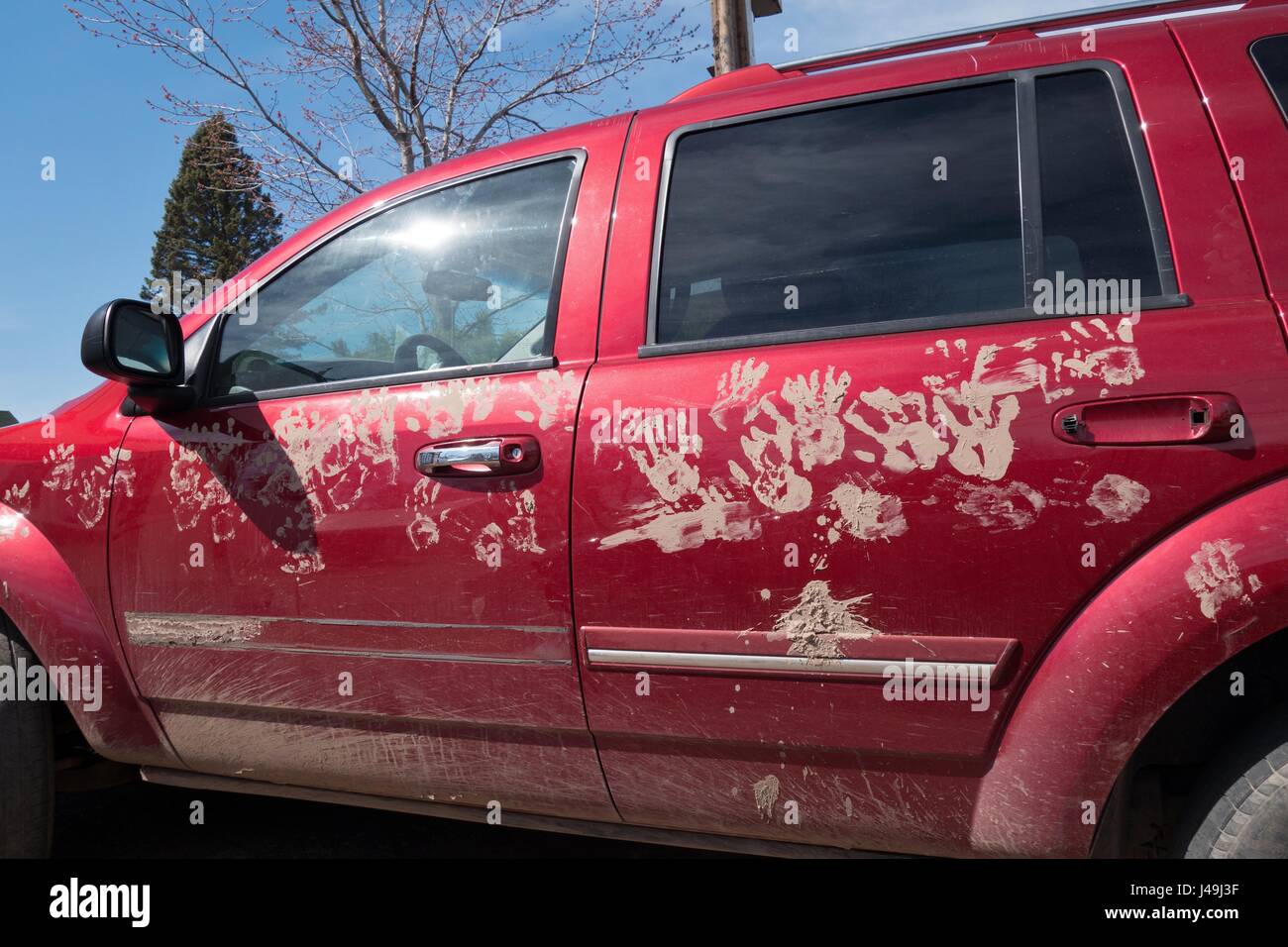 Ein rote SUV mit schlammigen Hand druckt auf der Außenseite. Stockfoto