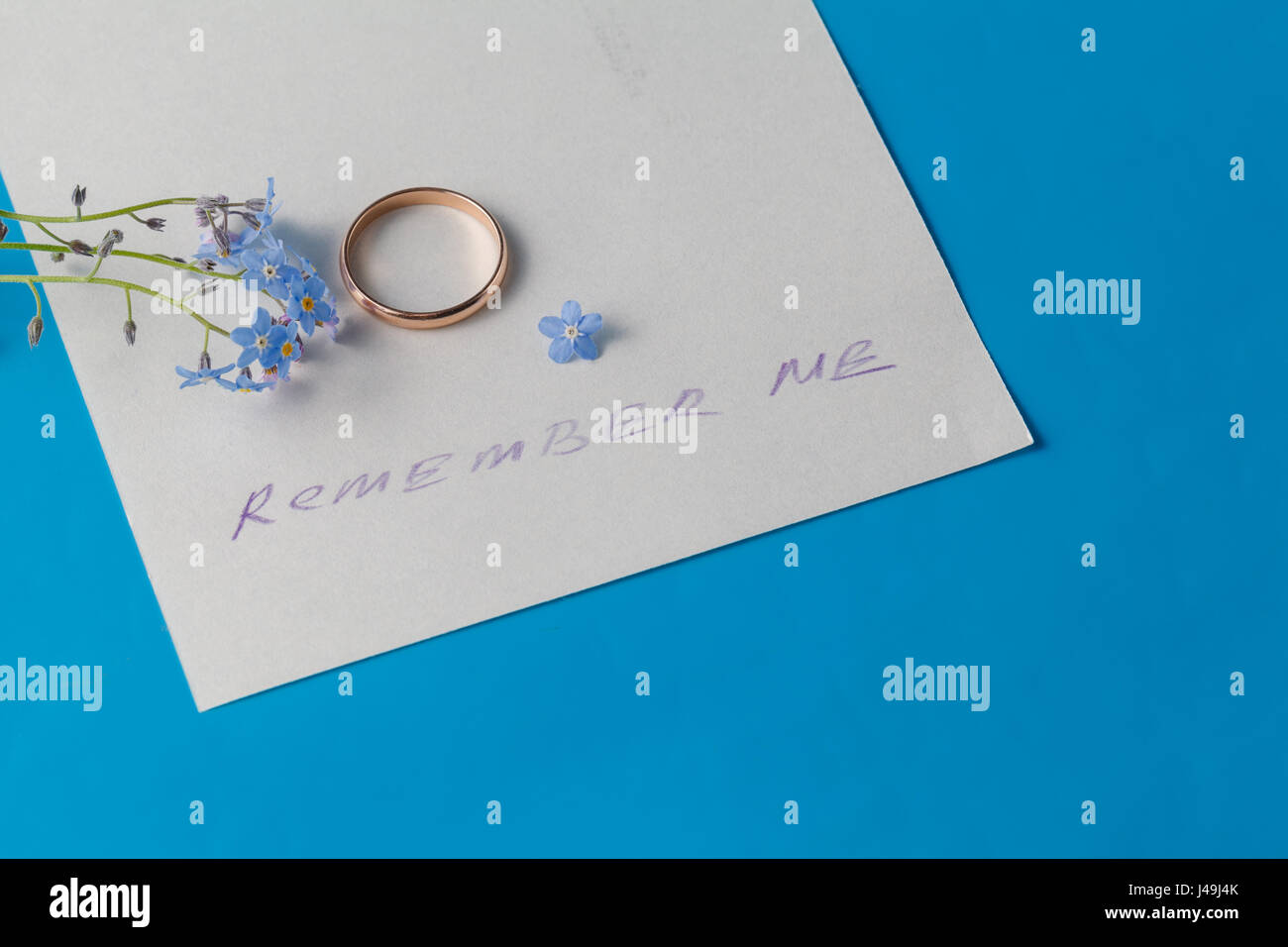 "Denk an mich» Konzept. blaue Blumen (Vergissmeinnicht) auf Papier mit Botschaft Stockfoto