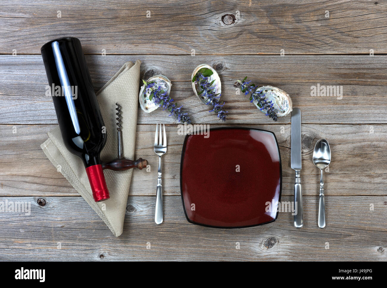 Abendessen-Einstellung mit Natur Dekorationen und Flasche Rotwein auf rustikalen Holztisch in flachen Laien-Ansicht Stockfoto