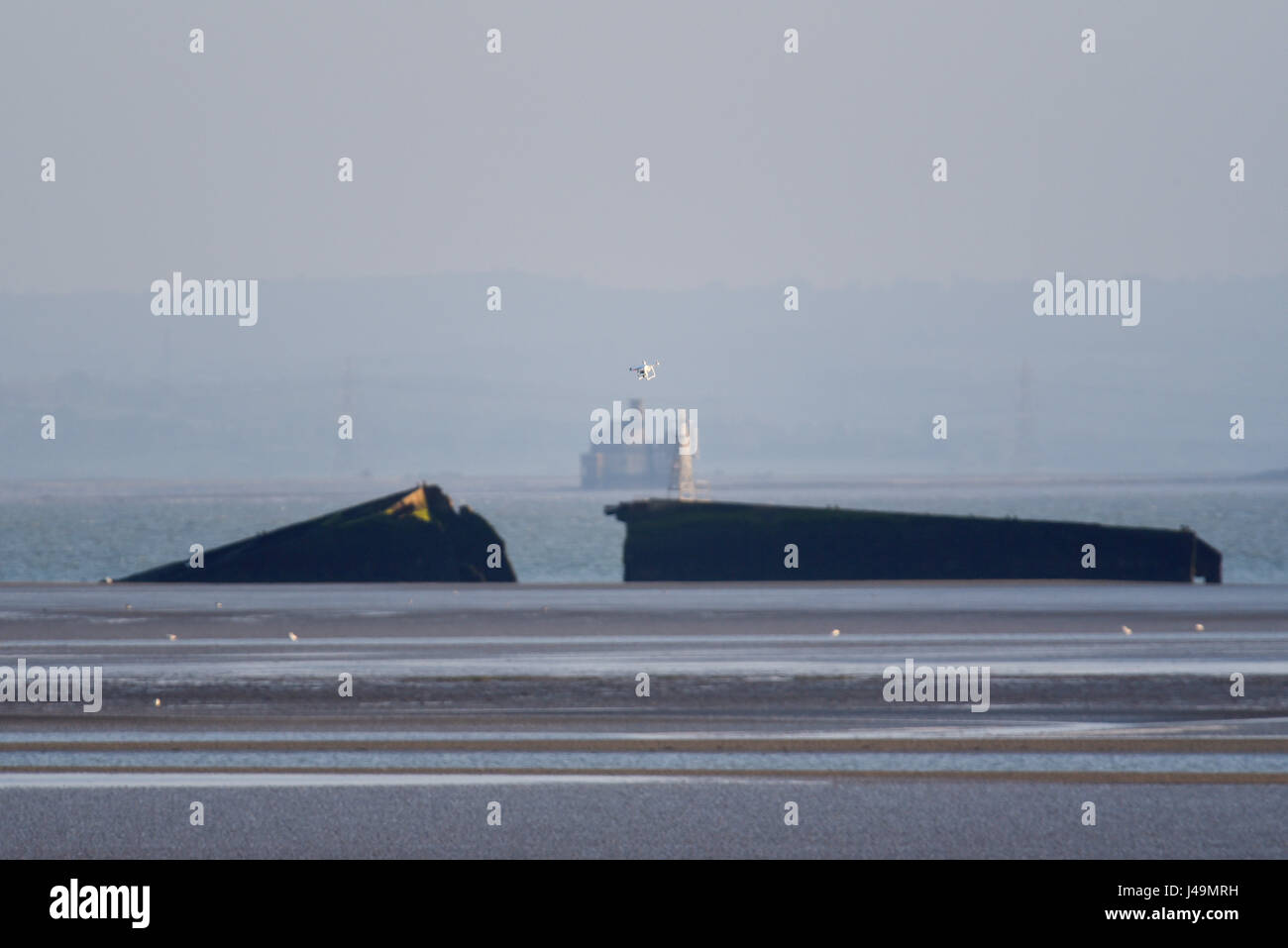 Eine Drohne mit Kamera fliegt zum Mulberry Harbour in der Themse Mündung Stockfoto
