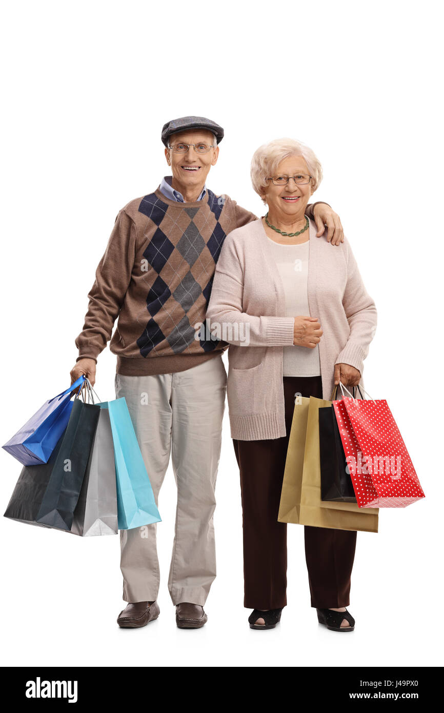 In voller Länge Portrait von Senioren mit Einkaufstüten, die in die Kamera schaut und lächelt auf weißem Hintergrund isoliert Stockfoto