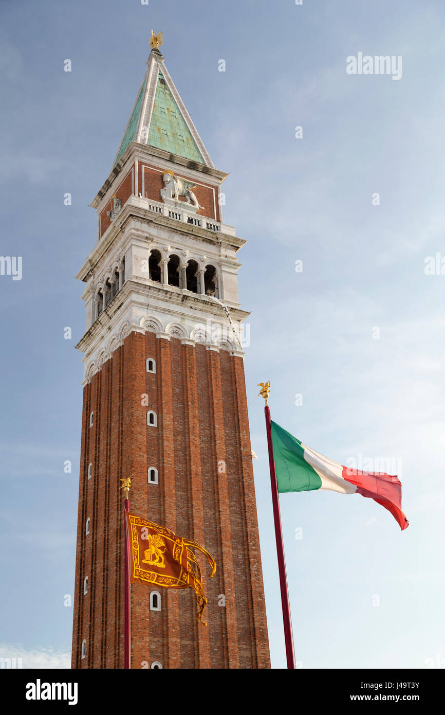 Italien, Venedig, die aus rotem Backstein Turm der Markusturm mit venezianischen und italienischen Fahnen. Stockfoto
