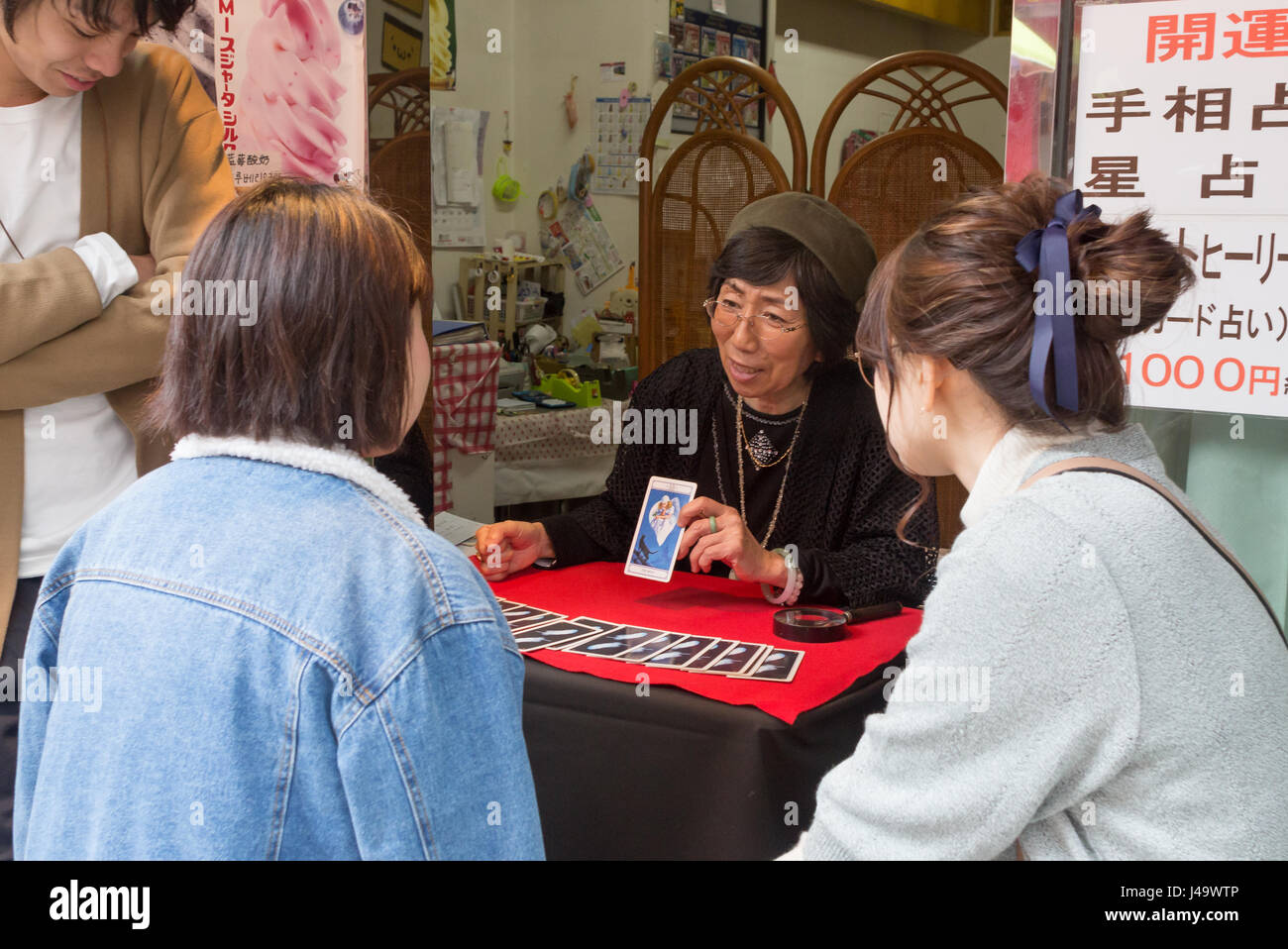 Nagasaki, Japan - 26. März 2017: Eine japanische Wahrsagerin ist die Tarot-Karten, einer Mädchen in einer verkehrsberuhigten Straße in Chinatown, Nagasaki lesen. Stockfoto