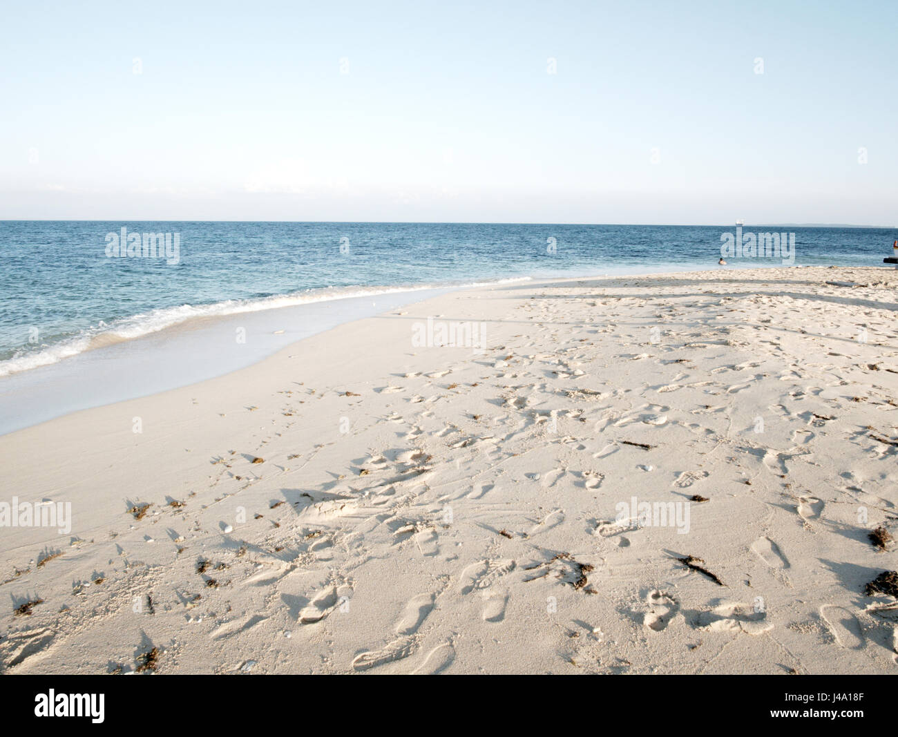 Ein umwerfendes Bild mit weißem Sand und spektakulären Meer in nicht bewölktem Stockfoto