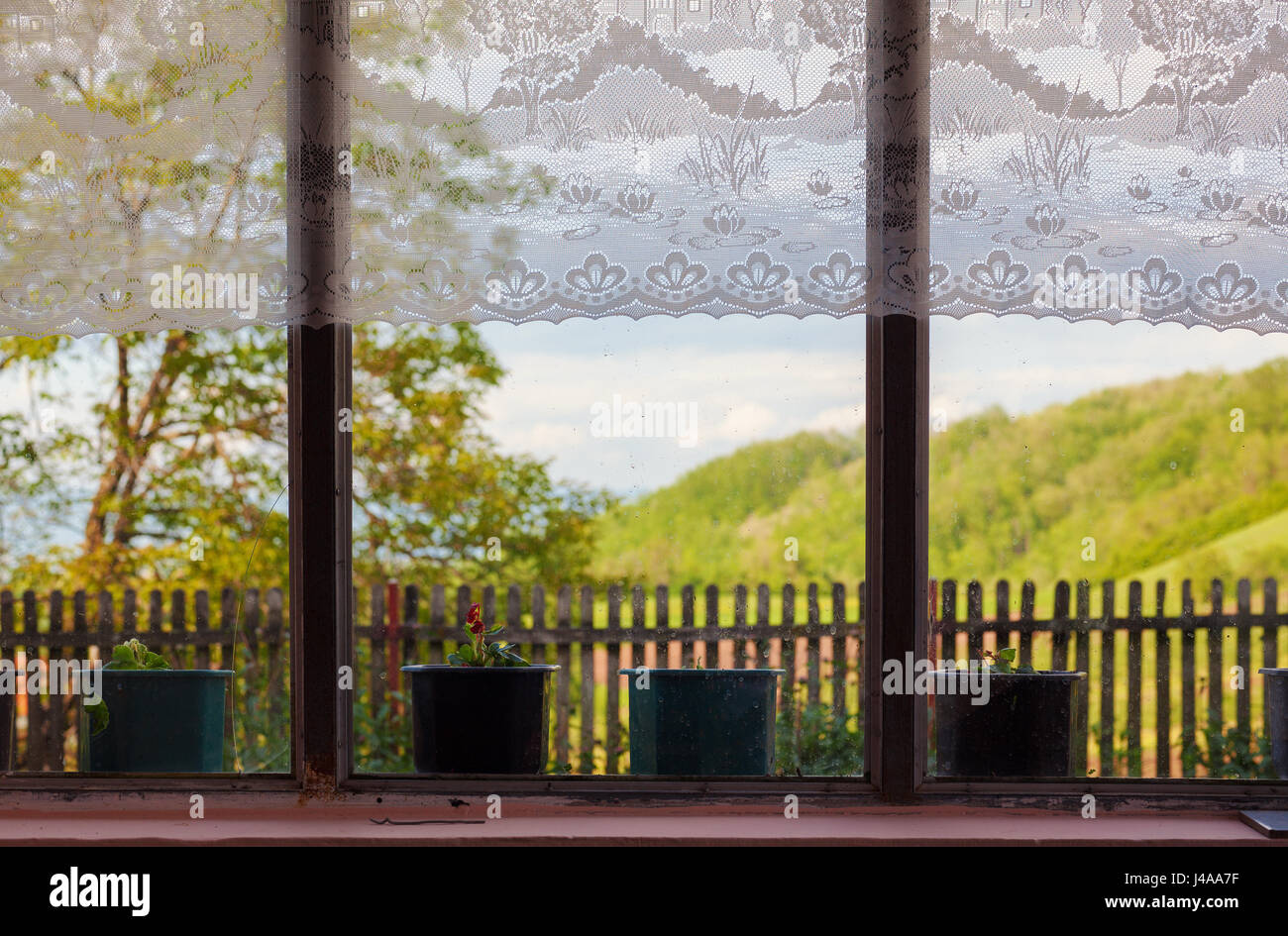 Innenraum eines Dorfes Haus Terrasse, Blick auf Windows und Blumenvasen, Stickerei auf der Oberseite als Dekoration, traditionelle handgefertigte Kunst aus Serbien. Stockfoto