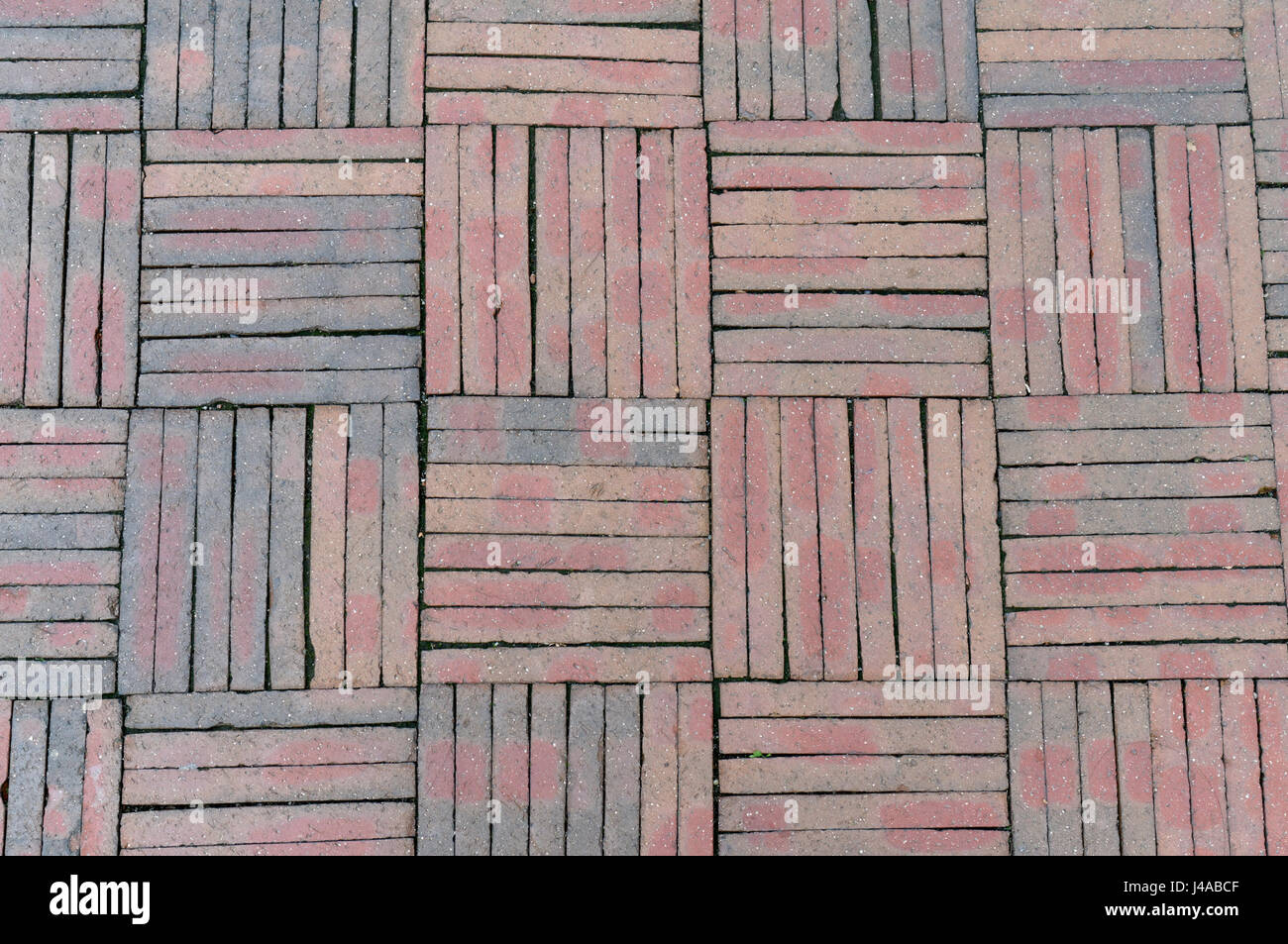 Bestehend aus rote Ziegeln in einem Parkett-Muster gegen Pflaster Stockfoto