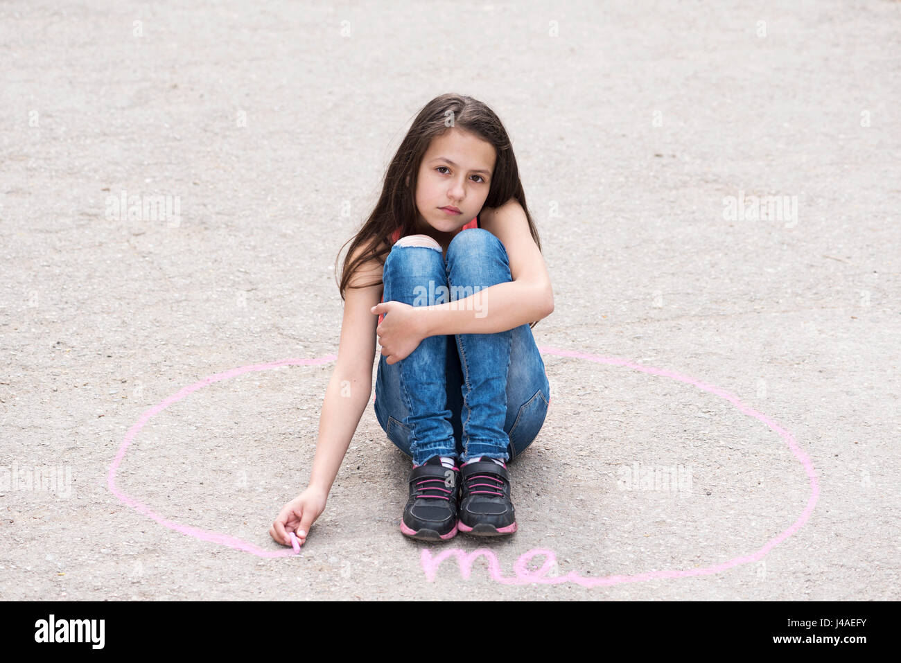 Trauriges Mädchen sitzen auf dem Boden in einem Kreis Stockfoto