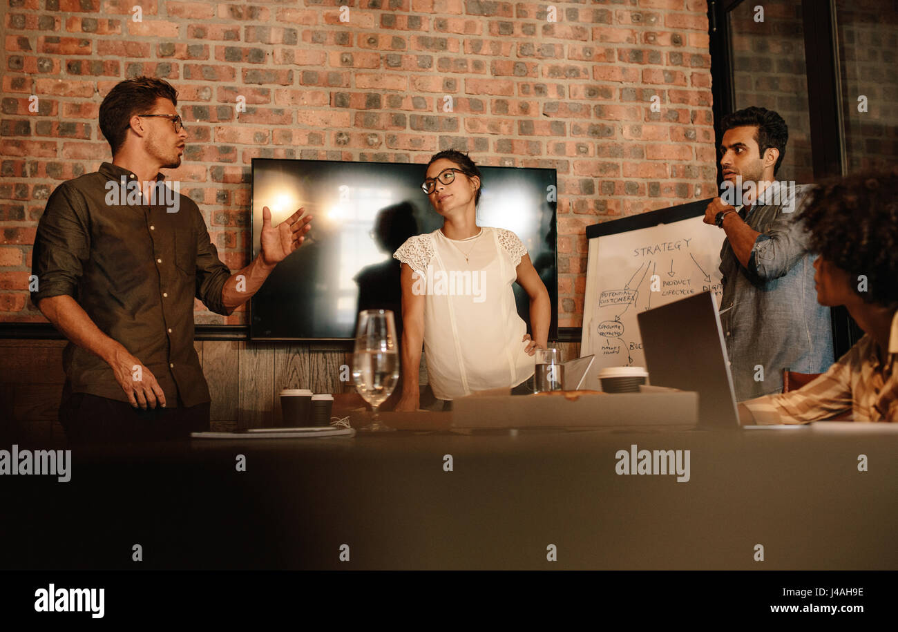 Gruppe von Jugendlichen mit einer Besprechung im Konferenzraum. Starten Sie Business-Team mit Gespräch über neues Projekt. Stockfoto