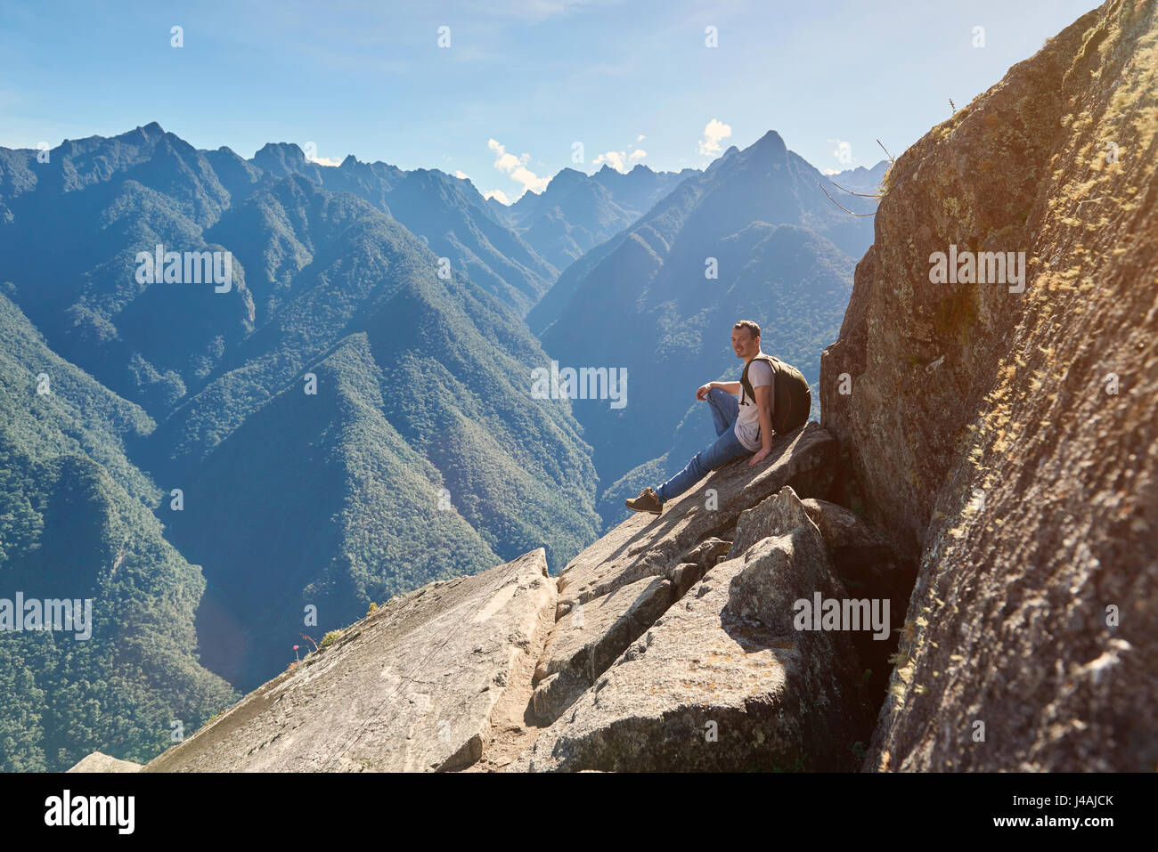 Menschen sitzen auf Berggipfel im sonnigen Sommertag, lächelnd Mann mit Rucksack auf Wandern Stockfoto