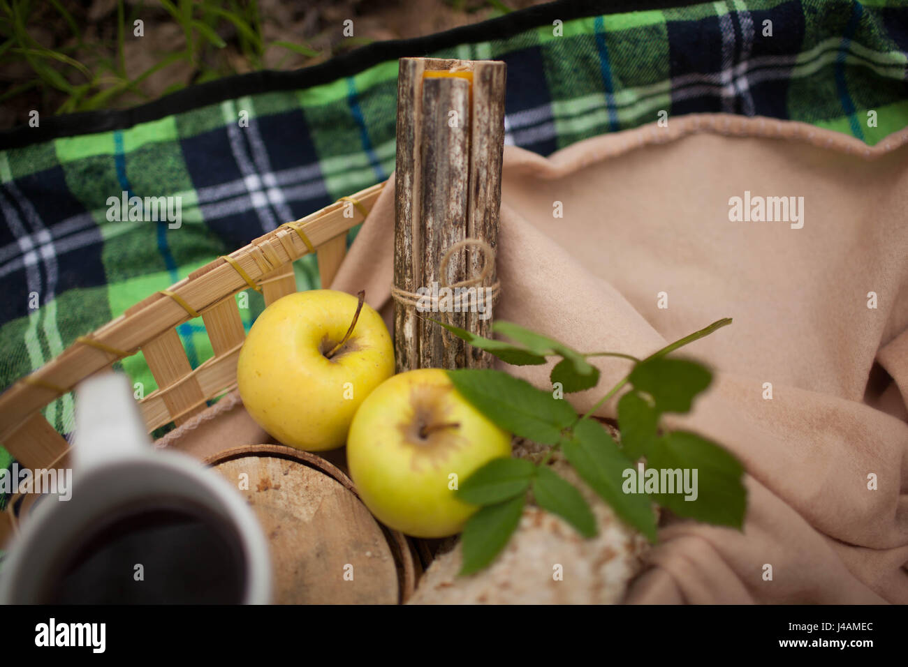 Tasse Tee und zwei Äpfel liegen auf der Decke Stockfoto